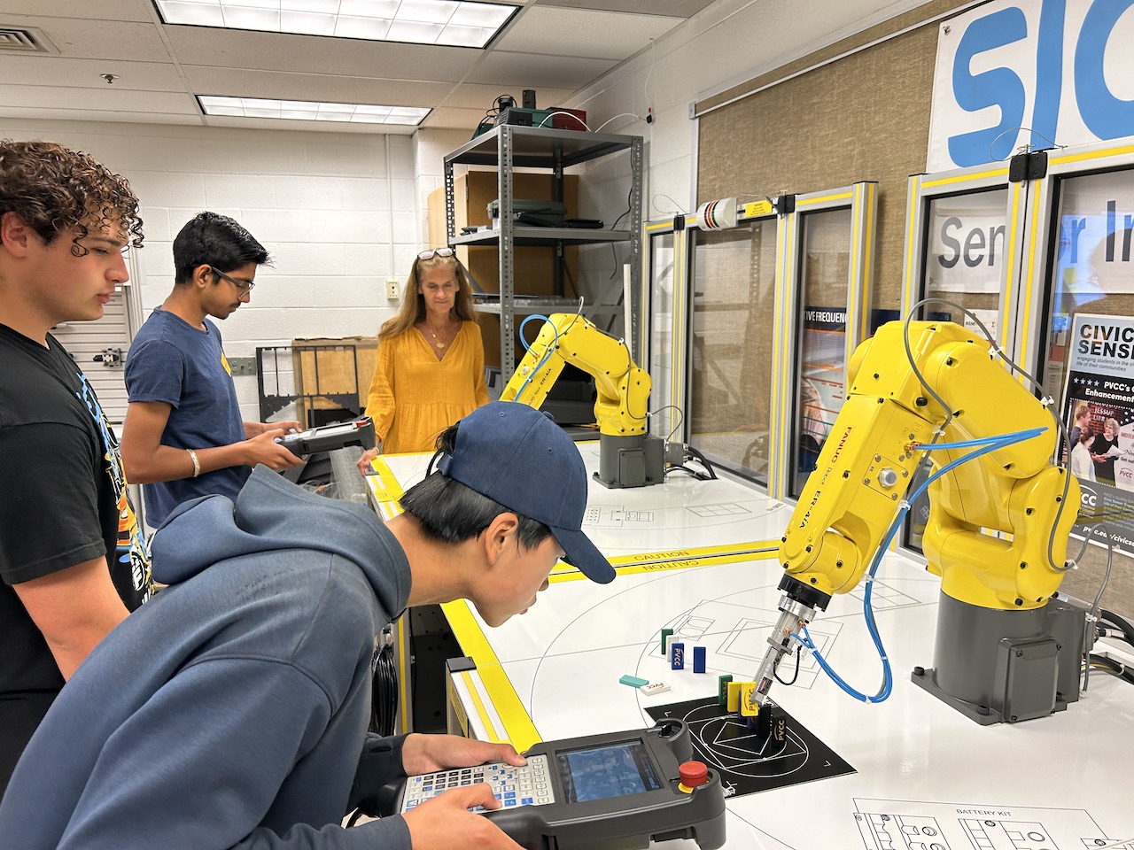 A Scholar operates a robotic arm during a visit to PVCC with the Engineering Tech. pathway during a spring programming day.
