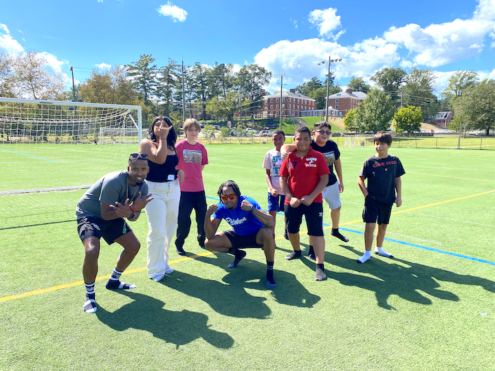 Starr Hill Pathways scholars and community partners pose on a sunny sports field.