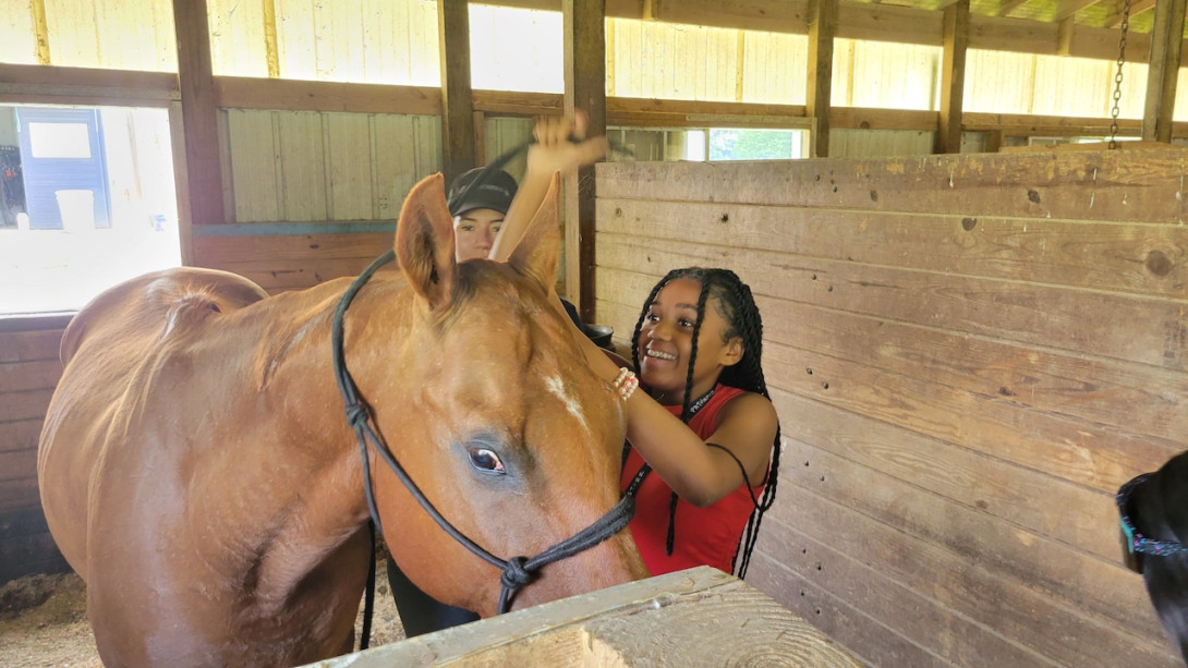 An SHP Scholar pets a horse at Ohana Horse Farm in Louisa for the Veterinarian/Veterinarian Technician Pathway.