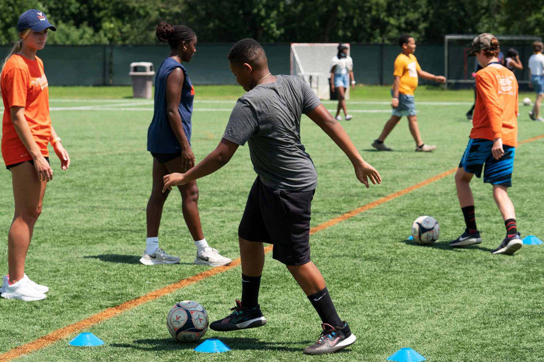 Students play with a soccer ball on a field